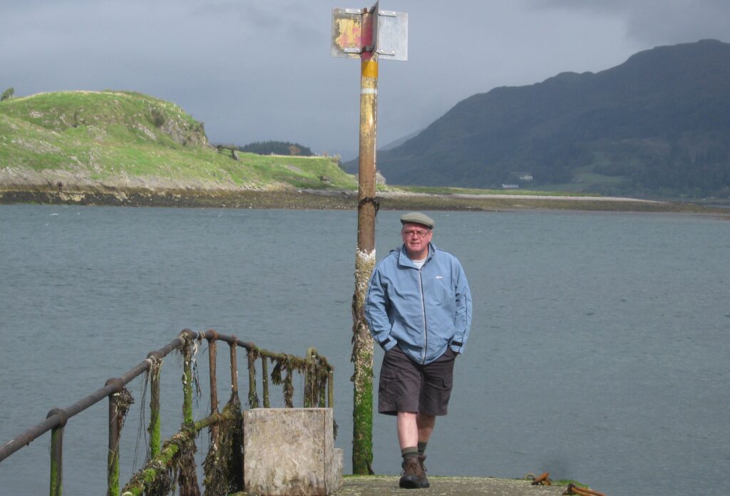 Man on jetty walking towards the camera towards the shore